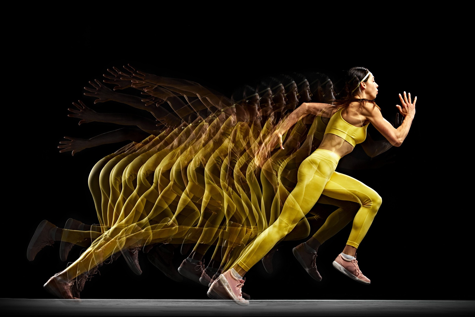 Concentrated and focused woman, athlete in motion, running, training against black background with stroboscope effect